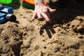 Warm spring little boy playing with toy cars in the sandbox. child boy playing car toy in sandbox outdoor Royalty Free Stock Photo